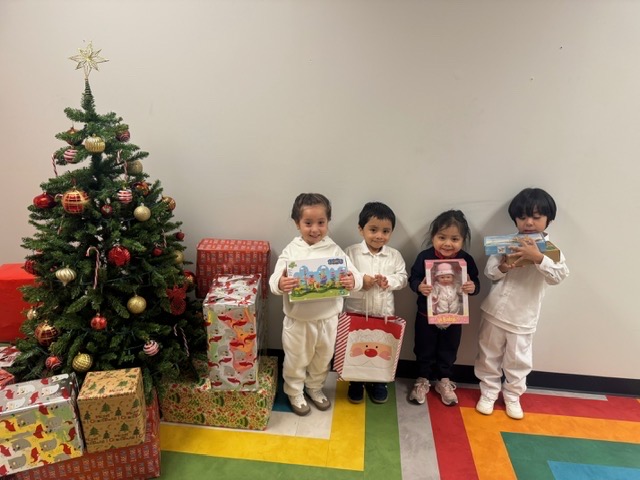 4 little kids holding presents